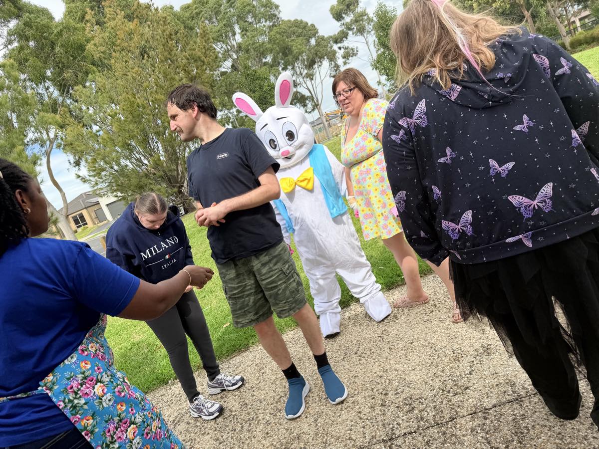 Participants and Newdawn support workers together outdoors at a community Easter event.